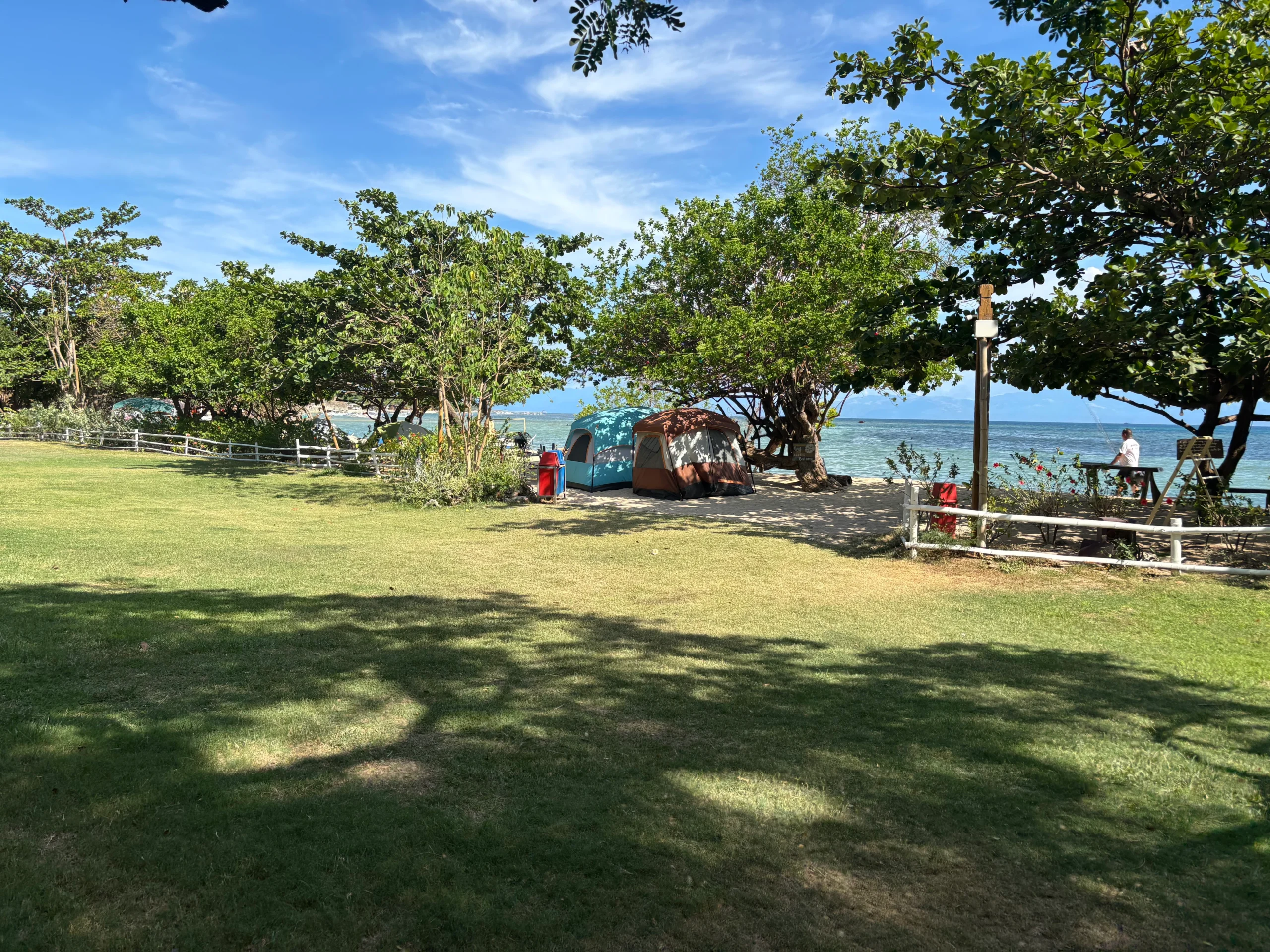 Tent in a shaded beachfront camping area at Stilts Calatagan