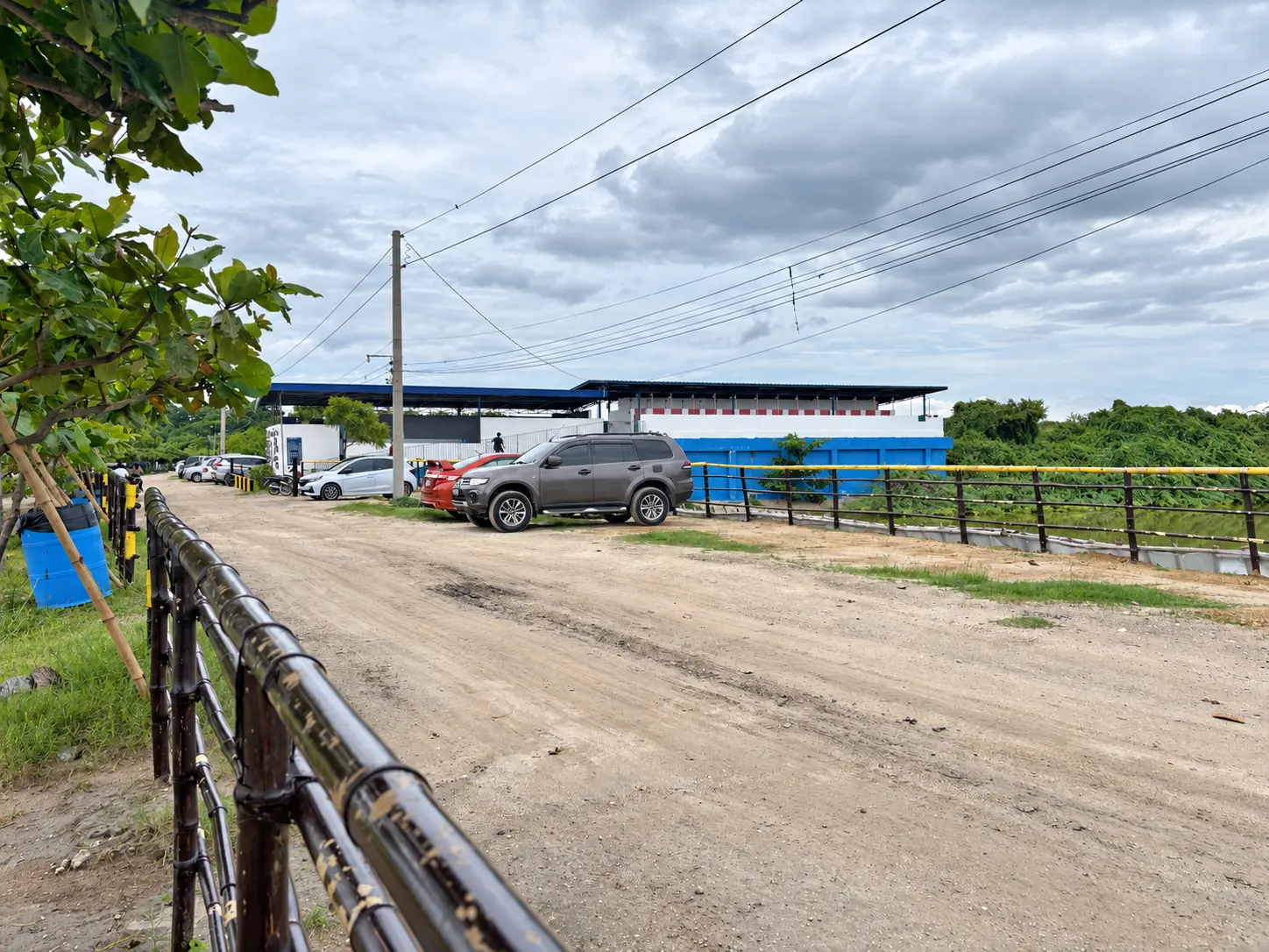 Dirt parking approach and vehicles at Manuel Uy Beach Resort