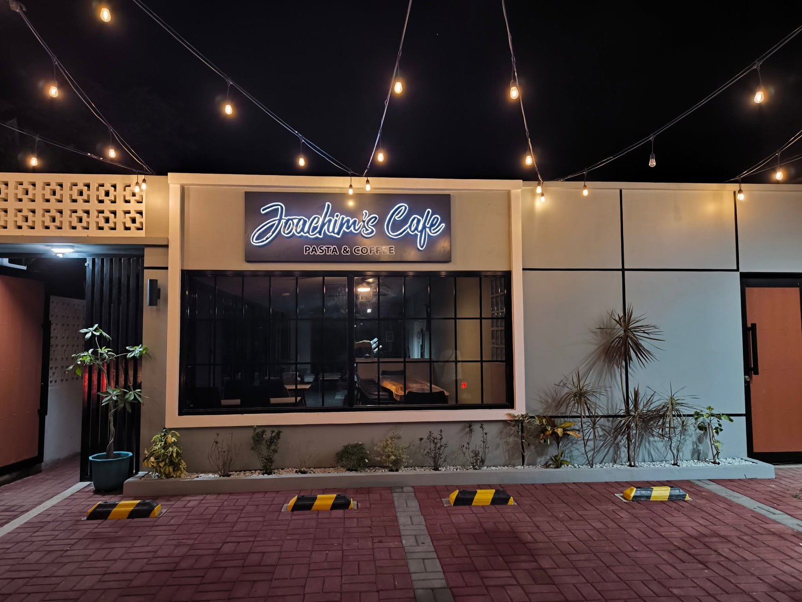Joachim's Cafe + Bistro exterior with illuminated sign and string lights