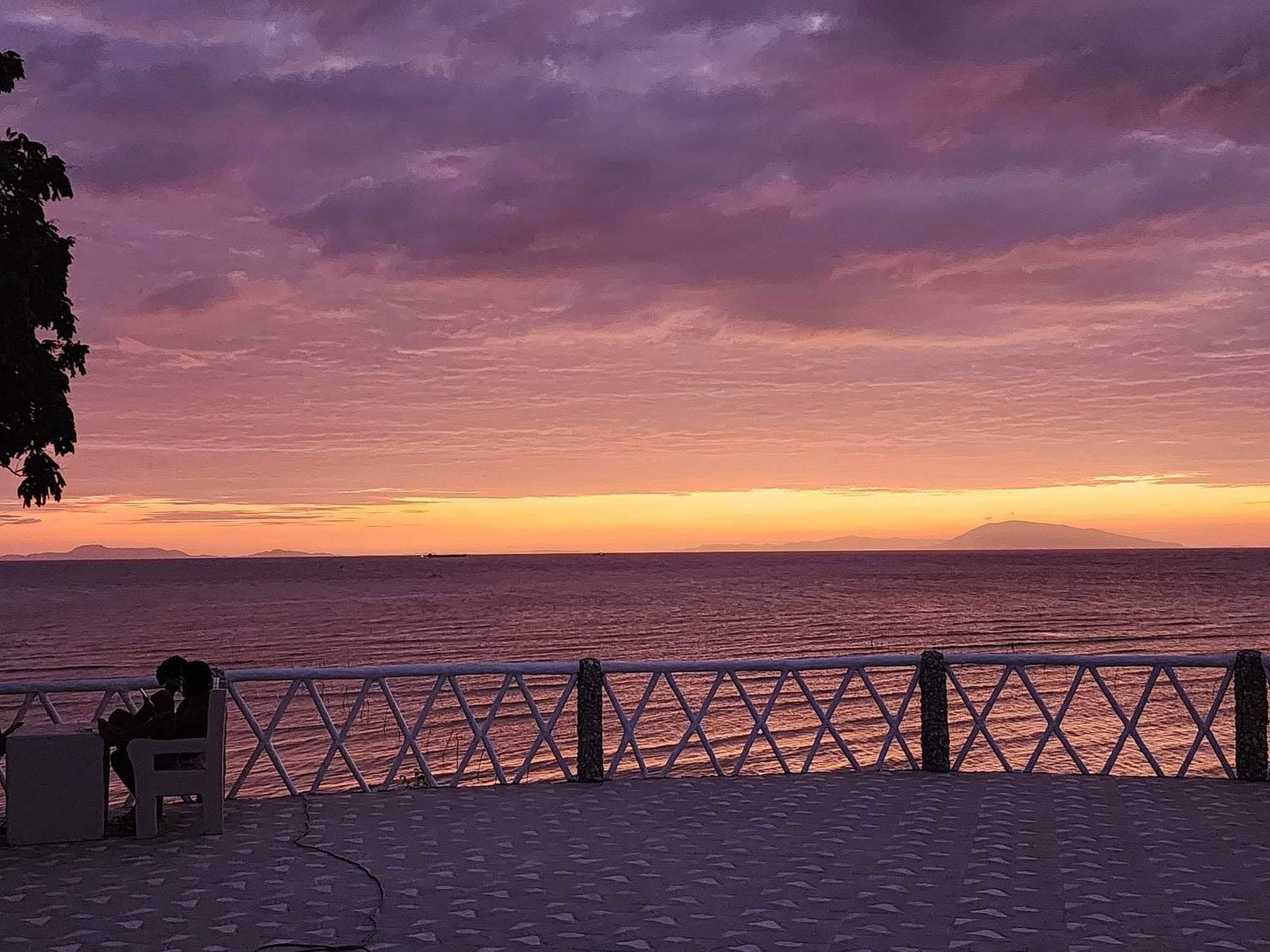 Sunset over the sea from Villa Marca Beach Resort's waterfront railing