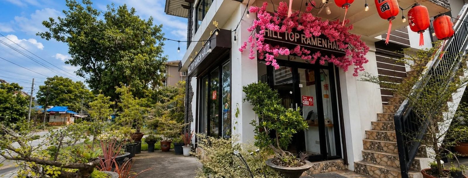 Hilltop Ramen Hauz entrance with red lanterns and pink floral decoration