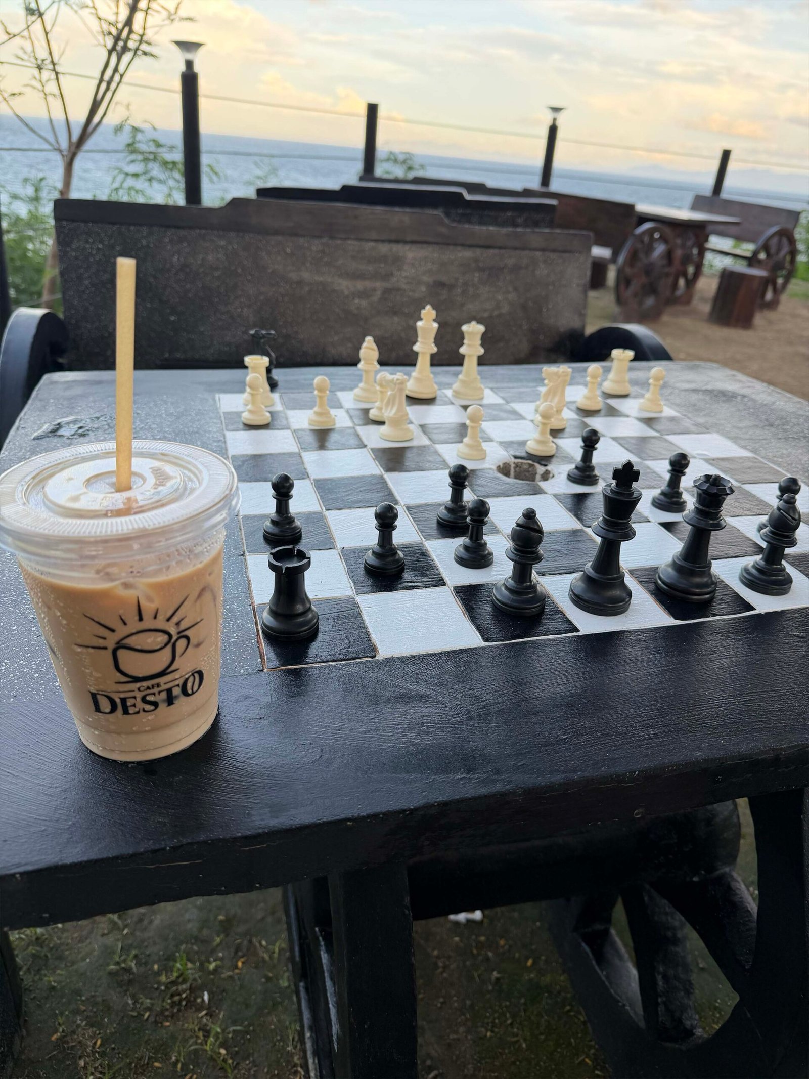 Iced drink beside a chessboard at Café Desto