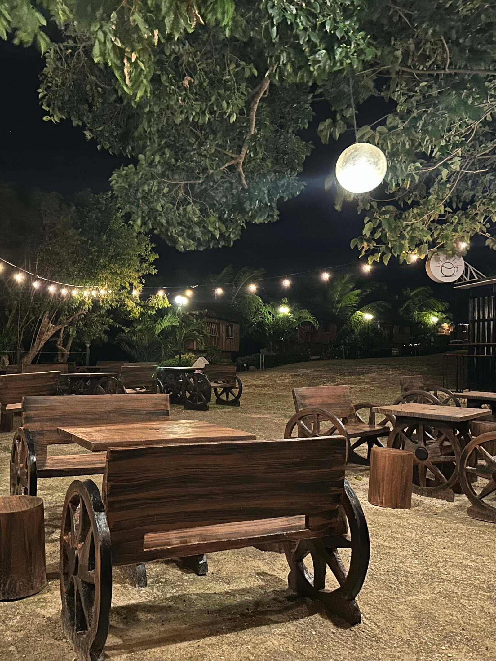 Outdoor tables under string lights at Café Desto at night