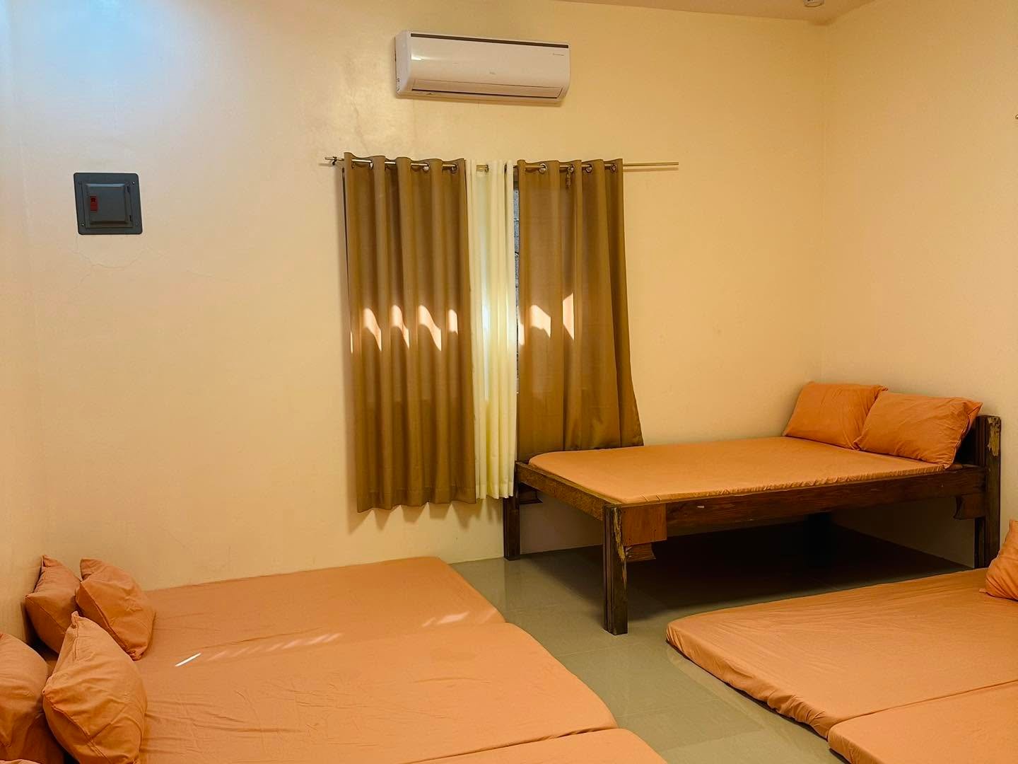 Beds and wall-mounted air conditioner in a room at Camp Wagi