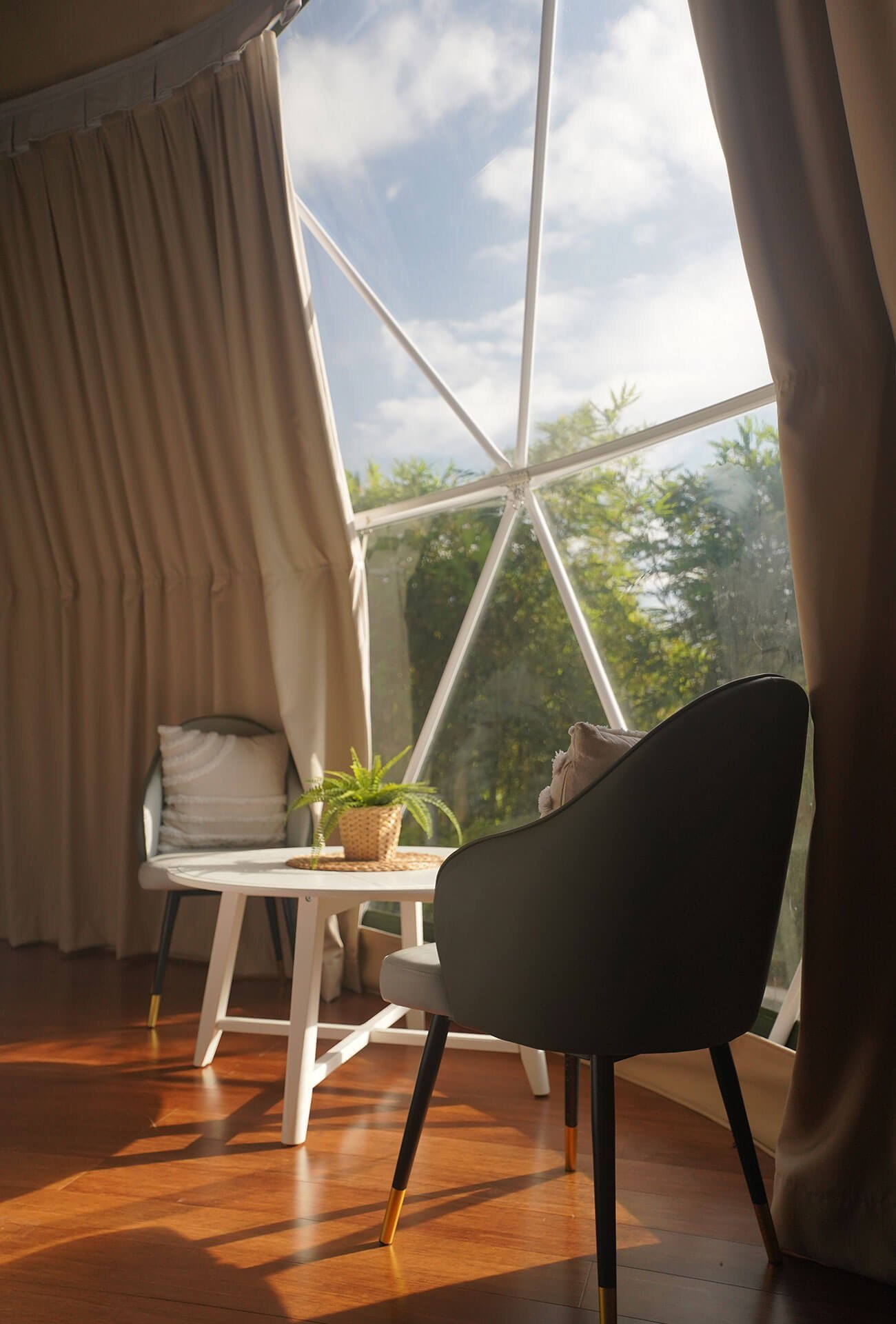 Lounge chairs beside the panoramic window inside a Cupola dome