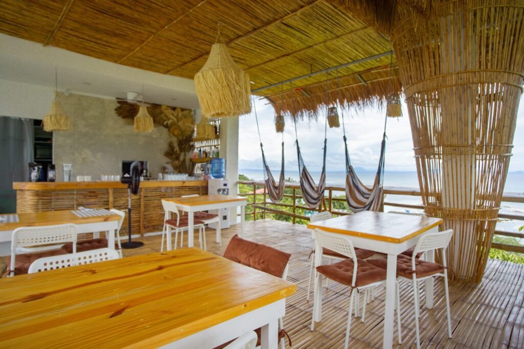 Covered dining area with wooden tables and sea views at Ionian Cabana