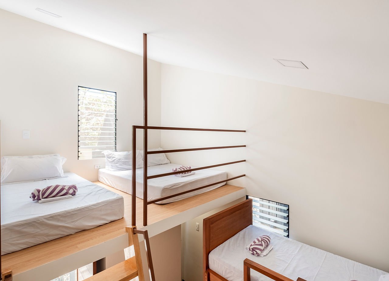 Beds on a raised sleeping platform inside a Tirta cottage